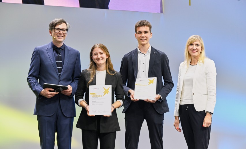 Jugend forscht - Bundessieger-Chemie 2025: Elisabeth Fischermann und Tom Kreßbach mit FCI Geschäftsführerin Ulrike Zimmer und dem Moderator Ralph Caspers © Jugend forscht Jugend forscht - Bundessieger-Chemie 2025: Elisabeth Fischermann und Tom Kreßbach mit FCI Geschäftsführerin Ulrike Zimmer und dem Moderator Ralph Caspers © Jugend forscht