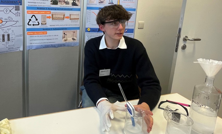 Tom Lippok erklärt an seinem Stand den Besuchern seinen Wettbewerbsbeitrag. © VCI Hessen / Heike Blaum Tom Lippok erklärt an seinem Stand den Besuchern seinen Wettbewerbsbeitrag. © VCI Hessen / Heike Blaum