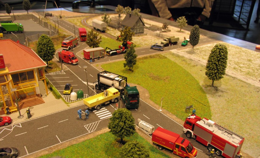 TUIS-Diorama: Im Vordergrund ist hinter dem Feuerwehrwagen das Modell des weißen Gasflaschen-Bergebehälters sichtbar. - Foto: © VCI/Rother TUIS-Diorama: Im Vordergrund ist hinter dem Feuerwehrwagen das Modell des weißen Gasflaschen-Bergebehälters sichtbar. - Foto: © VCI/Rother